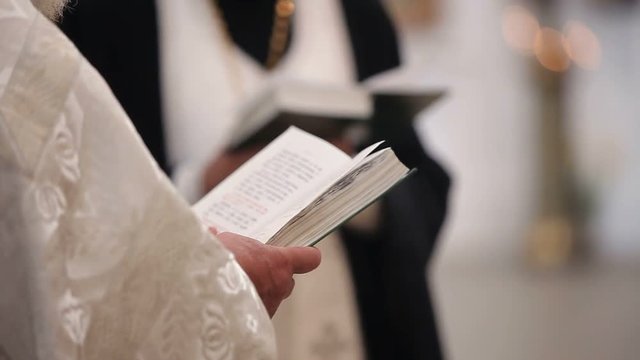 Priest with bible book in church
