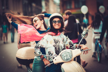 Multi ethnic girls on a scooter in european city © Nejron Photo