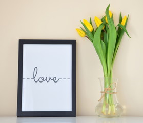 zółte tulipany i ramka z napisem kocham