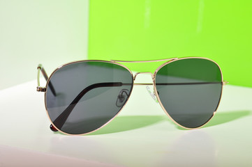 Sunglasses on white and green background