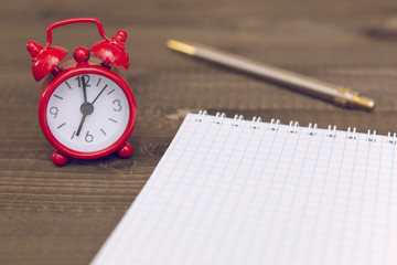 alarm clock, notepad and pen
