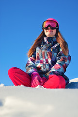 Fototapeta na wymiar Happy girl sitting on top of a snowy mountain