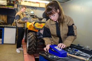 mechanic choosing tools to fix quad bike