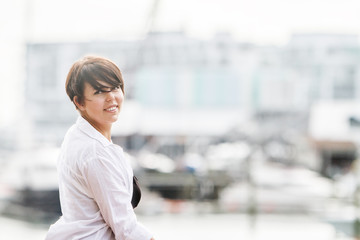 Fototapeta premium outdoor portrait of young happy smiling woman on urban city background