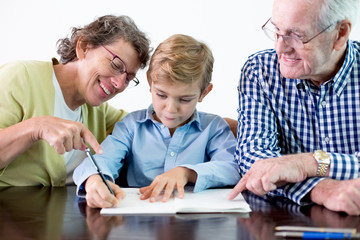 Diligent Grandson Doing Homework With Grandparents