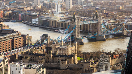 London city center with most know famous town attraction lifting Tower Bridge over river Thames. Tower of London in from of the view is under a sunshine rays. 