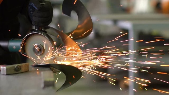 Man works circular saw. Flies of spark from hot metal. The man's hard work. Man Chlef and smooth surface. Man worked over the steel. close-up of hand and electric saws metal. Close-up of hand tool.