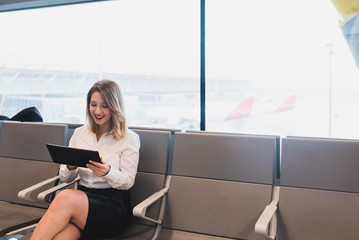Smiling young female browsing tablet. Horizontal indoors shot.