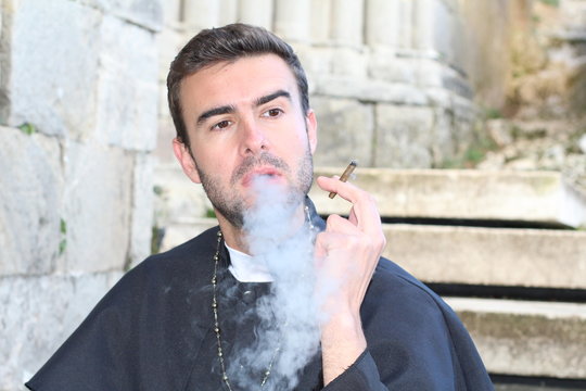 Priest smoking while taking a break