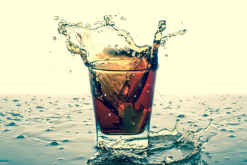 Splashing in glass with soda, ice cubes, white background. Old retro vintage style. 