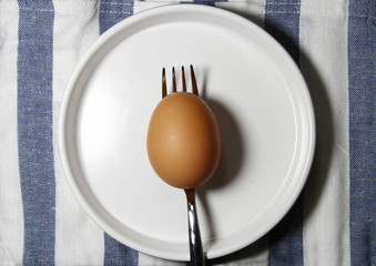 A brown egg on a fork