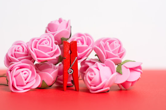 colorful wooden clothespin - abstract vision of woman surrounded by roses. Happy Women's Day greeting 