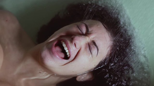  depressed, crazy woman lying in the tub desperately screams