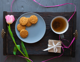 Mother's Day, woman's day. tulips ,presents ,tea and sweets on wooden background