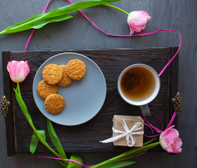 Mother's Day, woman's day. tulips ,presents ,tea and sweets on wooden background