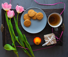 Mother's Day, woman's day. tulips ,presents ,tea and sweets on wooden background