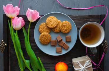 Mother's Day, woman's day. tulips ,presents ,tea and sweets on wooden background