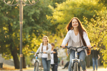 Cute girl riding bicycle in park