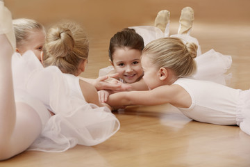 Naklejka premium Group of beautiful little ballerinas resting on the floor