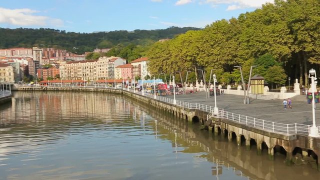Wide quay along Nervion river and view on colorful buildings in Bilbao, Spain