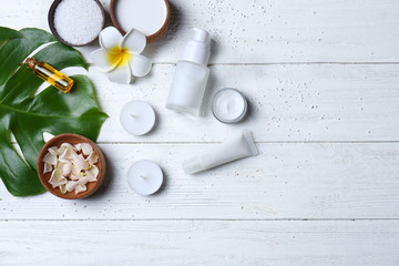 Natural cosmetics and leaf on wooden background