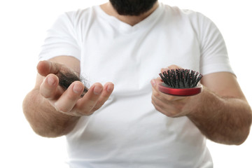 Adult man with hair brush on white background, closeup. Hair loss concept