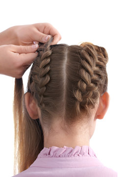Hairdresser doing hairstyle to young woman on white background