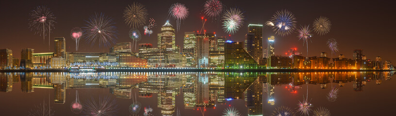 Panorama of Canary Wharf business district at night with firework, celebration of the New Year in...