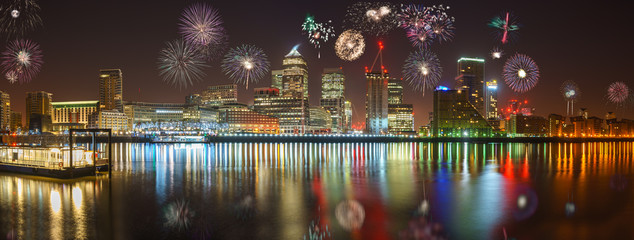 Panorama of Canary Wharf business district at night with firework, celebration of the New Year in...