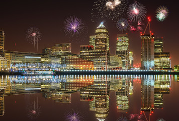 Panorama of Canary Wharf business district at night with firework, celebration of the New Year in...