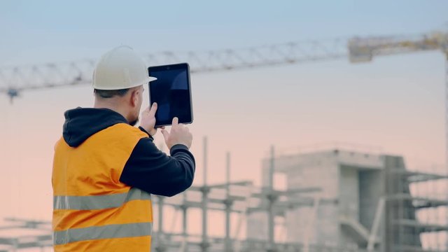 construction engineer at the construction site using the tablet