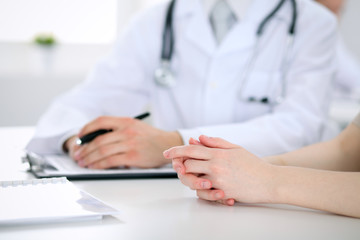 Fototapeta premium Doctor and patient are discussing something, just hands at the table
