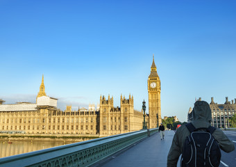 Obraz premium Big Ben and Houses of Parliament with cloudless sky and tourists walking on Westminster bridge, London, UK