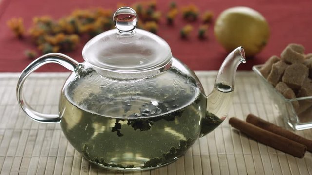 Brewing green tea in glass teapot