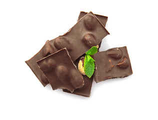 Broken chocolate pieces with nuts and mint leaves, isolated on white