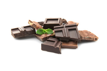 Broken chocolate pieces with nuts and mint leaves, isolated on white