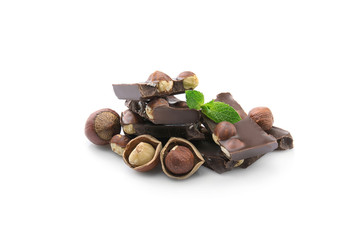 Broken chocolate pieces with nuts and mint leaves, isolated on white