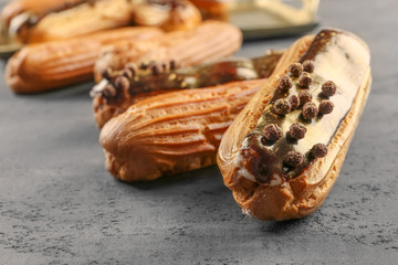 Delicious eclairs on grey textured background