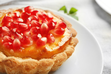 Tasty tart with fresh seeds of pomegranate served on plate, closeup