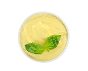 Creamy cheese and basil leaves in bowl, isolated on white