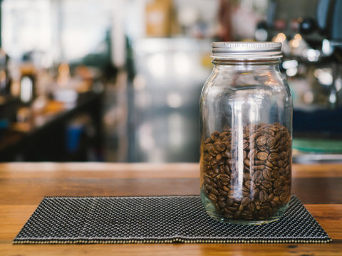 Coffee beans in a glass jar on the table