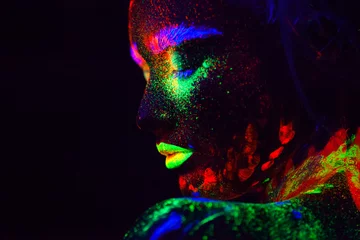 Schöne außerirdische Modellfrau mit blauem Haar und grünen Lippen im Neonlicht. Es ist ein Porträt eines schönen Modells mit fluoreszierendem Make-up, Kunstdesign einer Frau, die in UV mit buntem Make-up posiert © satyrenko