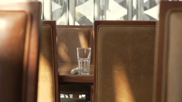 Restaurant elements concept, brown leather chair and glass next to window