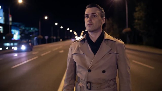 Time lapse, handsome young man in night city in middle of road, traffic. Night city, cars