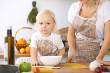 Happy family in the kitchen. Mother and child daughter  cooking tasty breakfest