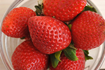 red ripe strawberries in a bowl - top view