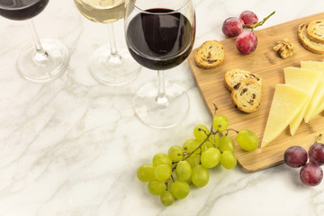White and red wine with cheese, bread and grapes