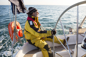 Mature Man Wearing Wind Jacket On Sailing Boat