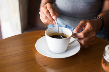 Young adult girl enjoying coffee and breakfast at a cafe 