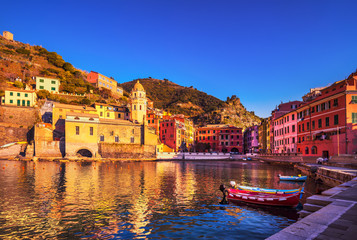 Vernazza village, church, boats and sea harbor on sunset. Cinque Terre, Ligury, Italy